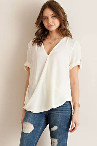Solid surplice top featuring roll up sleeve detail.